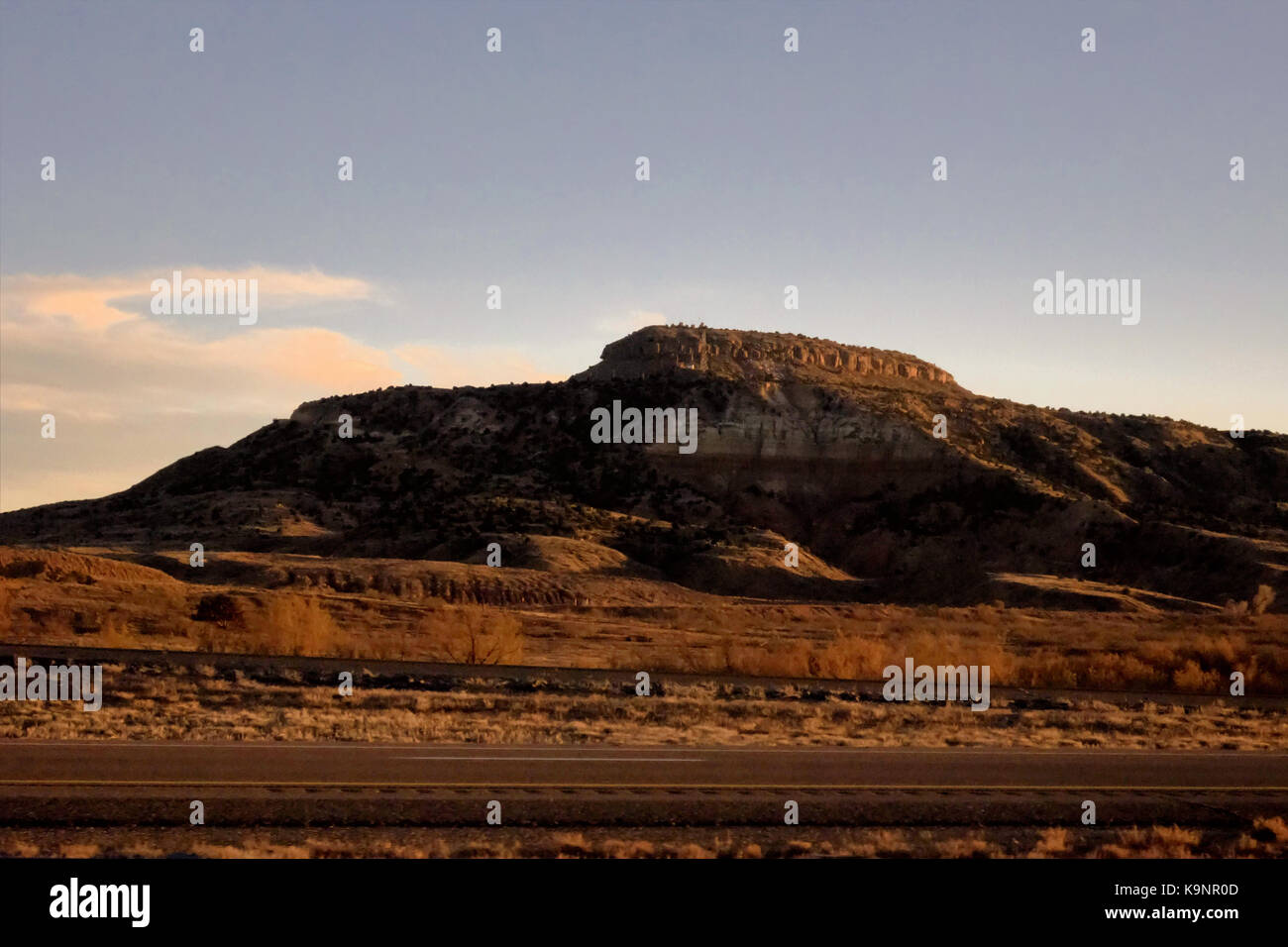 Ein rocky mountain Formation ständigen Licht durch eine orange Sonnenuntergang. Stockfoto