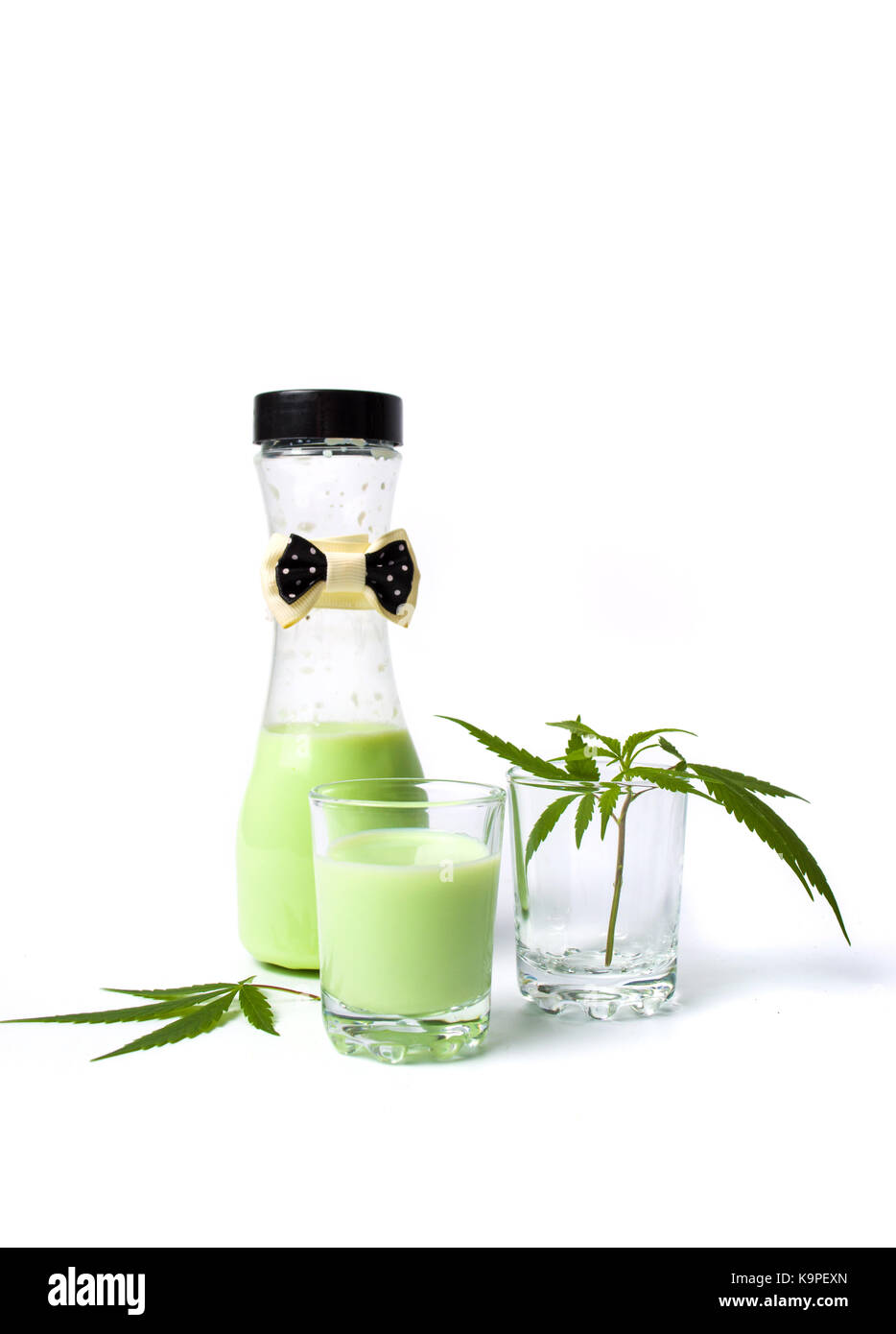 Grüne Milch mit Marihuana in Schale und Flasche Stockfoto