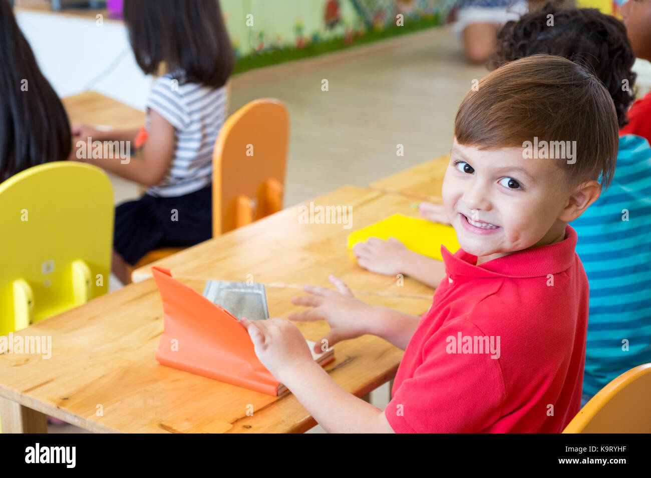 Kaukasische junge Ethnizität Kind im Klassenzimmer lächelnd mit Freunden im Kindergarten Schule Stockfoto