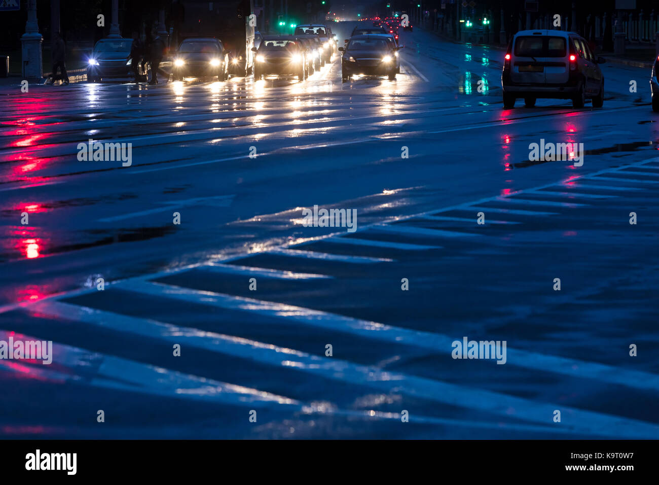Stadt Straße bei Nacht. Autos auf nasser Straße nach starkem Regen fahren. Stockfoto