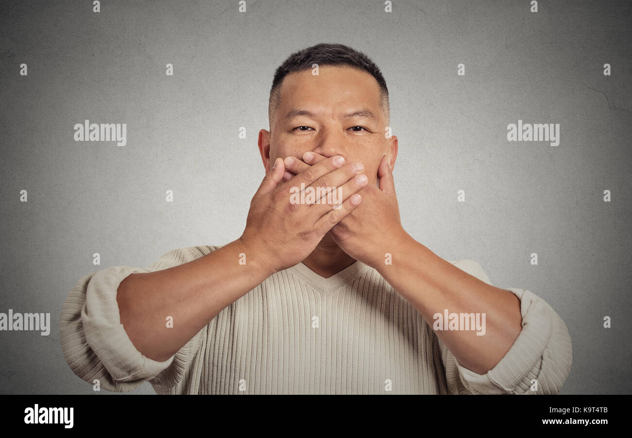 Closeup Portrait Porträt junger Mann studentische Mitarbeiterin Mitarbeiter über seinen Mund mit den Händen. Kein übel Konzept sprechen isoliert grauen Hintergrund. Menschliches Gesicht Stockfoto