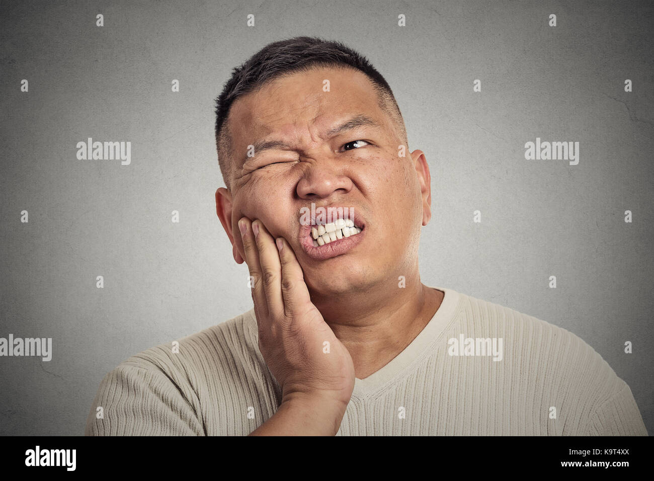 Closeup Portrait Porträt Mann mittleren Alters zu berühren Gesicht mit schlechten Schmerzen, Zahn Ache, isolierte grauen Hintergrund. Negative menschliche Emotionen, Gesichts ex Stockfoto