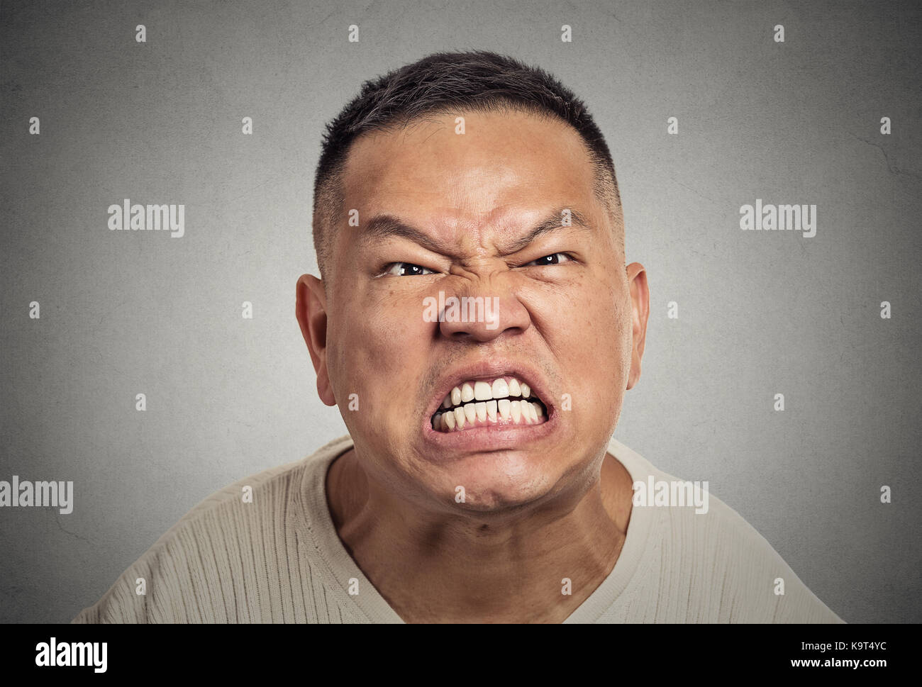 Nahaufnahme Porträt Kopfschuss wütend mittleren Alters Mann mit offenem Mund aggressiv schreien isoliert graue Wand Hintergrund. Negative menschliche Emotion Gesichts expr Stockfoto