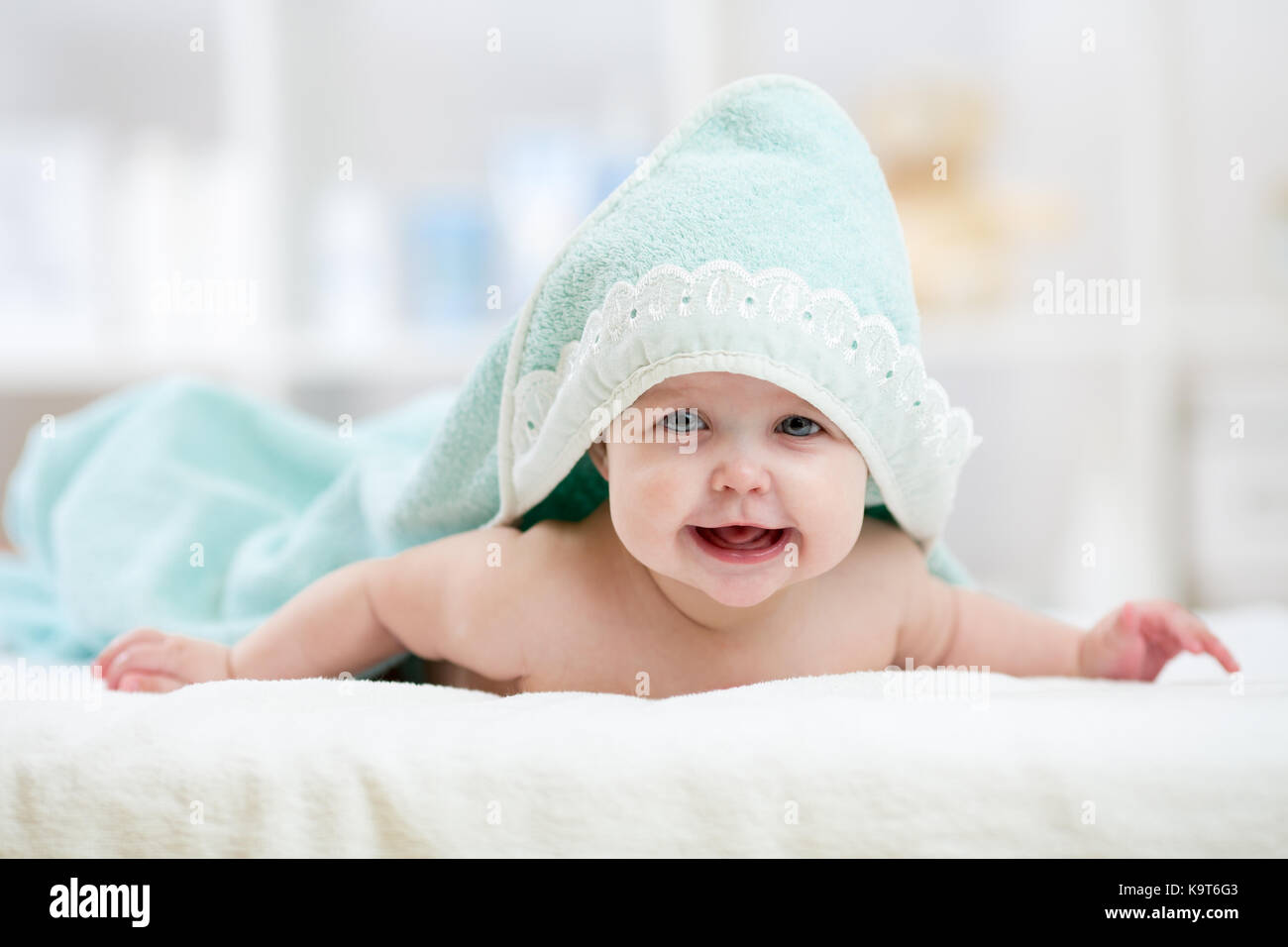 Babymädchen unter Handtuch im Schlafzimmer nach Baden oder Duschen. Textil-  und Bettwäsche für Kinder Stockfotografie - Alamy