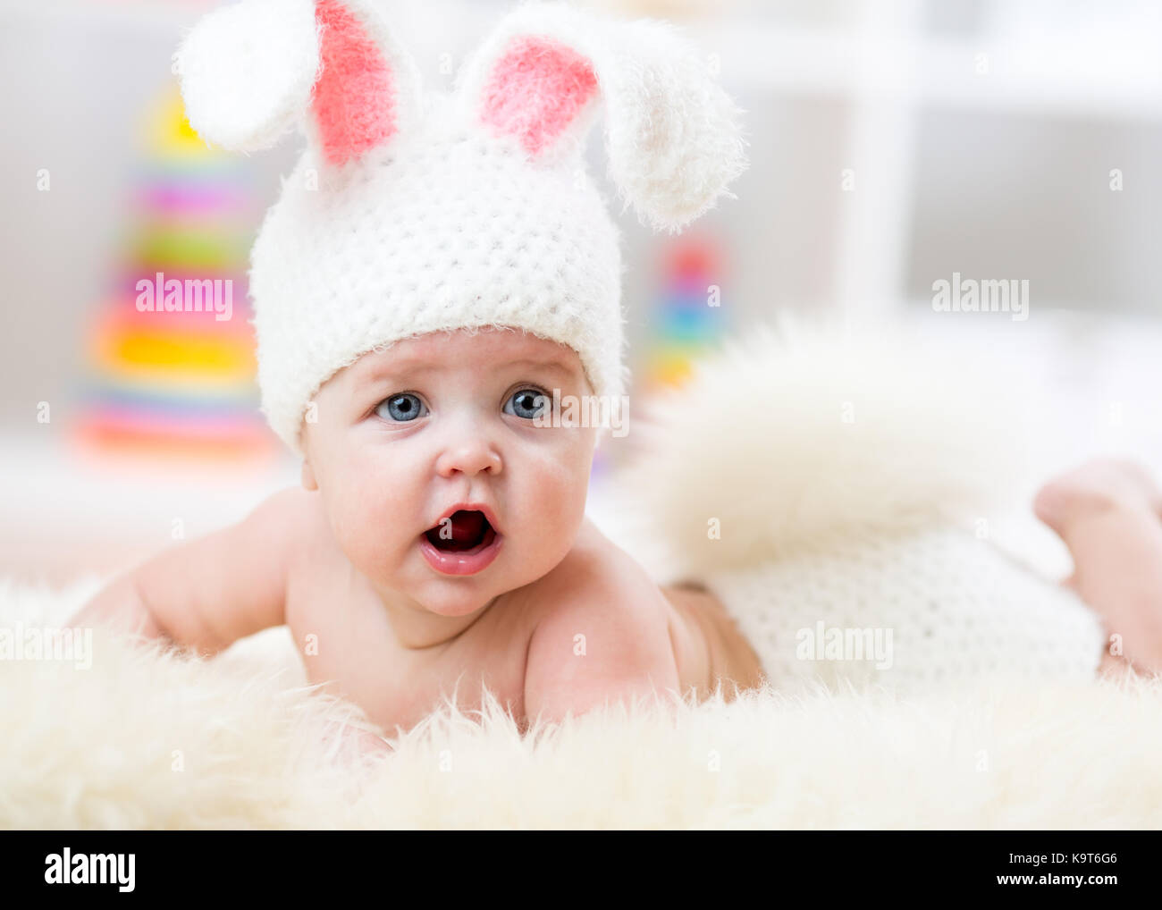 Lächelnd niedlichen Baby im Bunny Kostüm auf Pelz in Kindergärten liegen Stockfoto