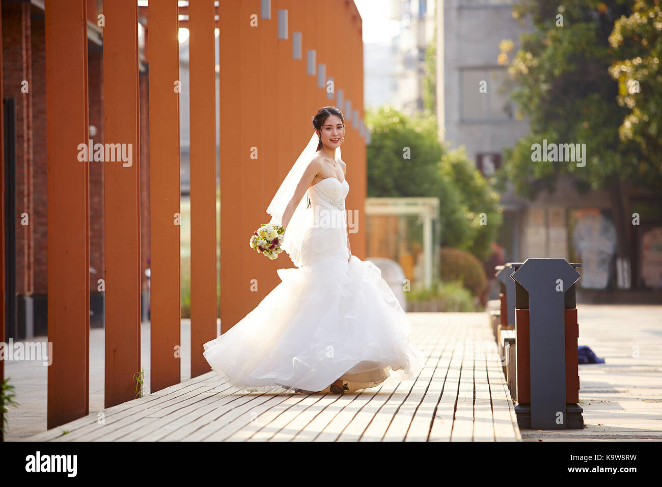 Outdoor Portrait von Jung und schöne asiatische Braut mit Blumenstrauß in der Hand. Stockfoto