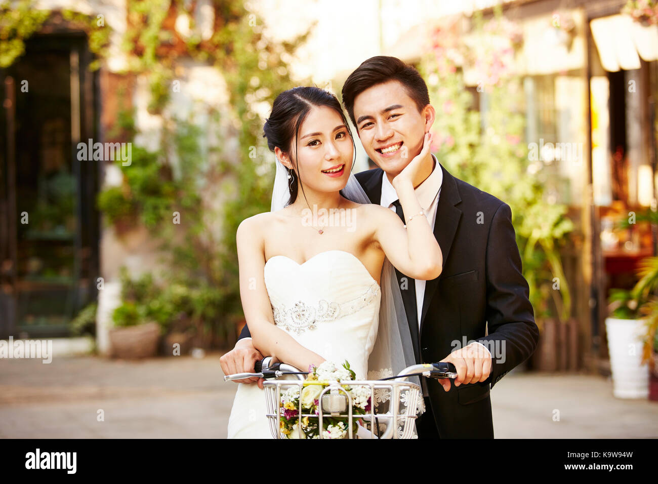 Gerne frisch Vermählte asiatischen Paar Spaß beim Fahrrad fahren. Stockfoto