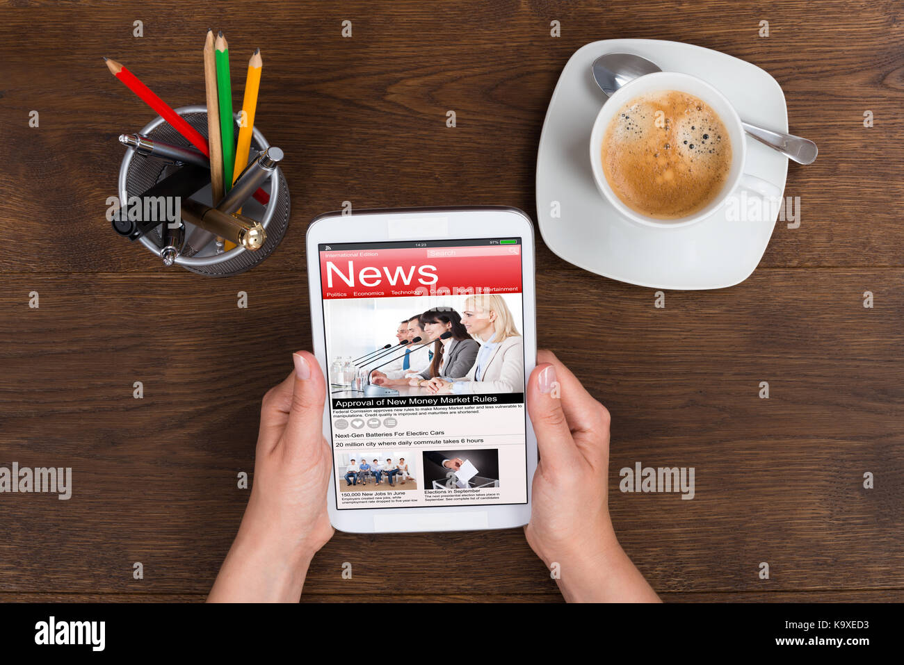 Nahaufnahme der Person Hände halten Handy News am Schreibtisch Stockfoto