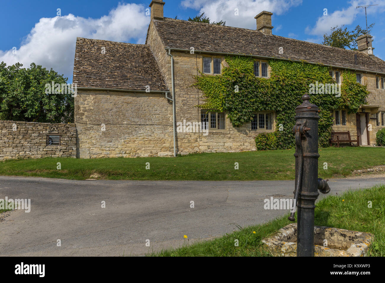 Wasserpumpe auf dem Dorfplatz in Little Barrington, Gloucestershire Stockfoto