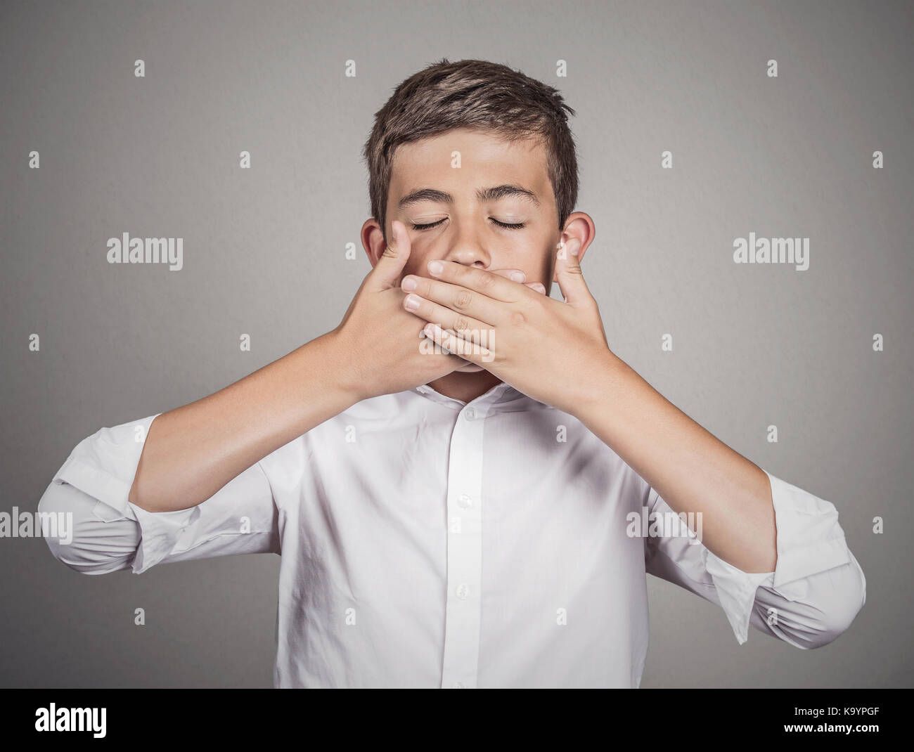 Porträt junger Mann, Student, Junge, der seinen Mund mit den Händen. Kein übel Konzept sprechen, isolierte grauen Hintergrund. Menschliche Emotionen, Gesicht Ausdruck Stockfoto