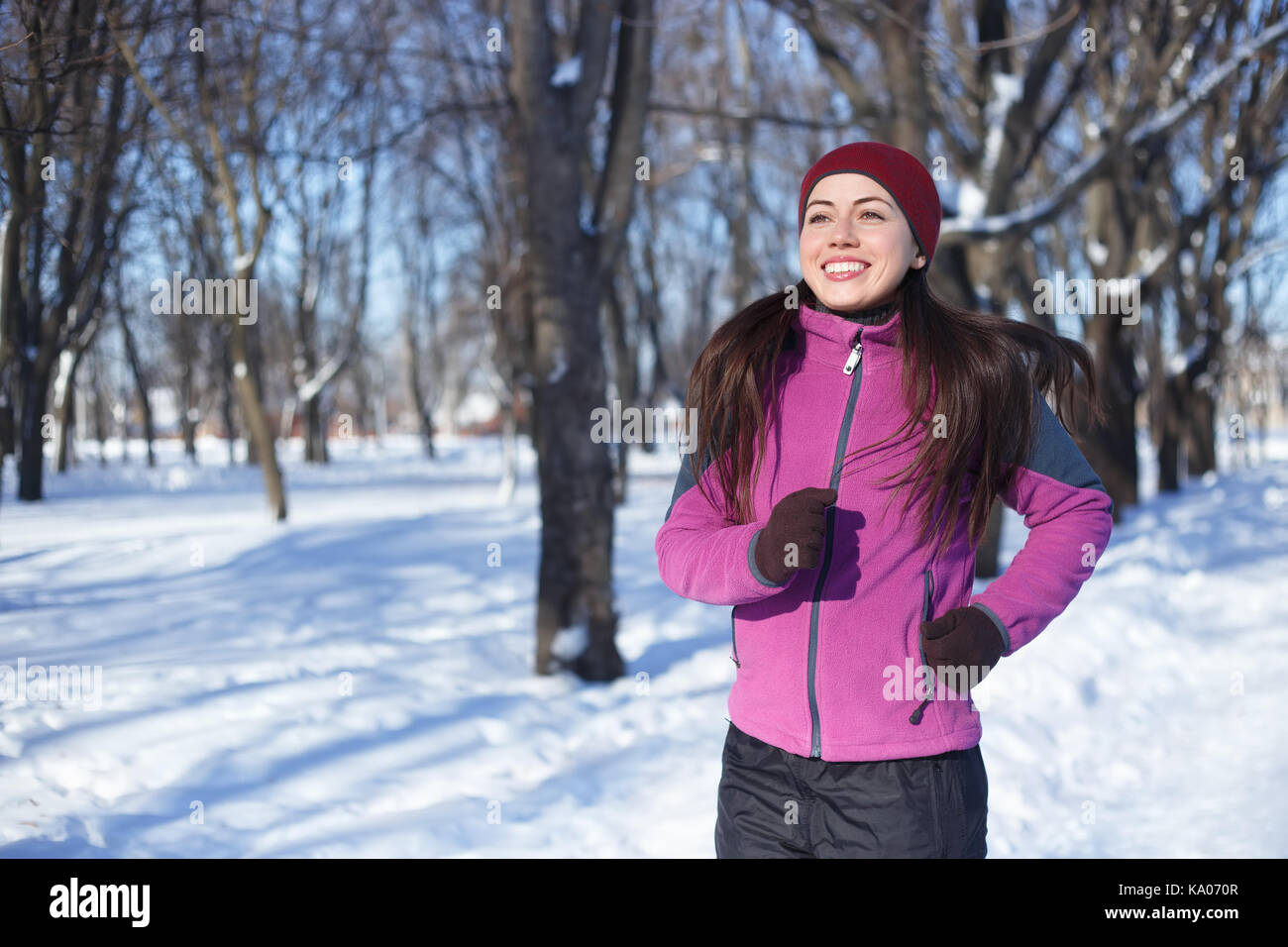 Laufsport Frau. Läuferin Joggen im kalten Winter Wald tragen warme Sportlich läuft Kleidung und Handschuhe. Fitness Happy girl läuft im Winter Stockfoto
