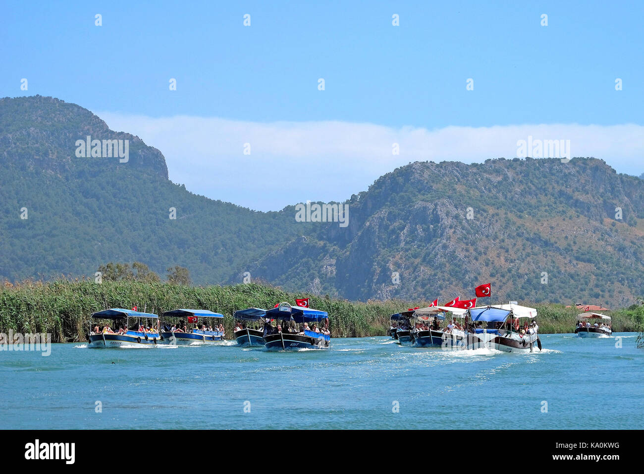 Ausflugsboote, die Urlauber entlang der Uferstadt Dalyan in der Türkei fahren Stockfoto