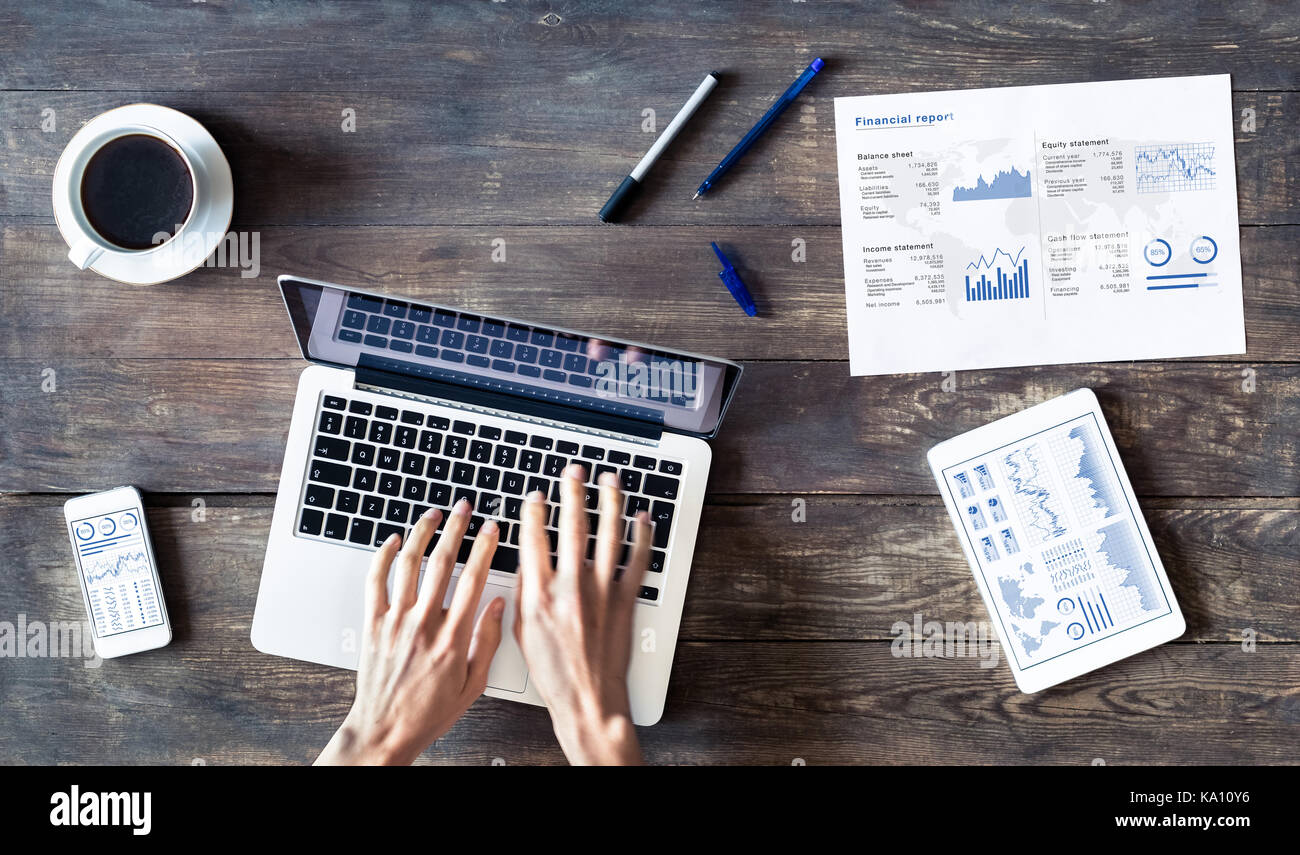 Business Person arbeiten mit finanziellen Bericht und Tabellen auf einem Holztisch Stockfoto