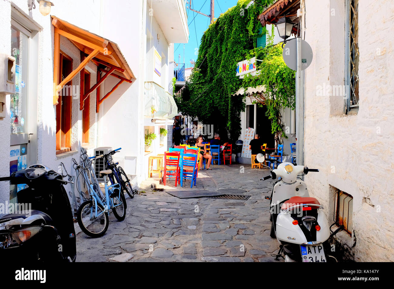 Skiathos, Griechenland. September 13, 2017. Eine Taverne kein Name mit farbigen Stühle und Tische in einer Seitenstraße in Skiathos Stadt auf der Insel von Skia genannt Stockfoto