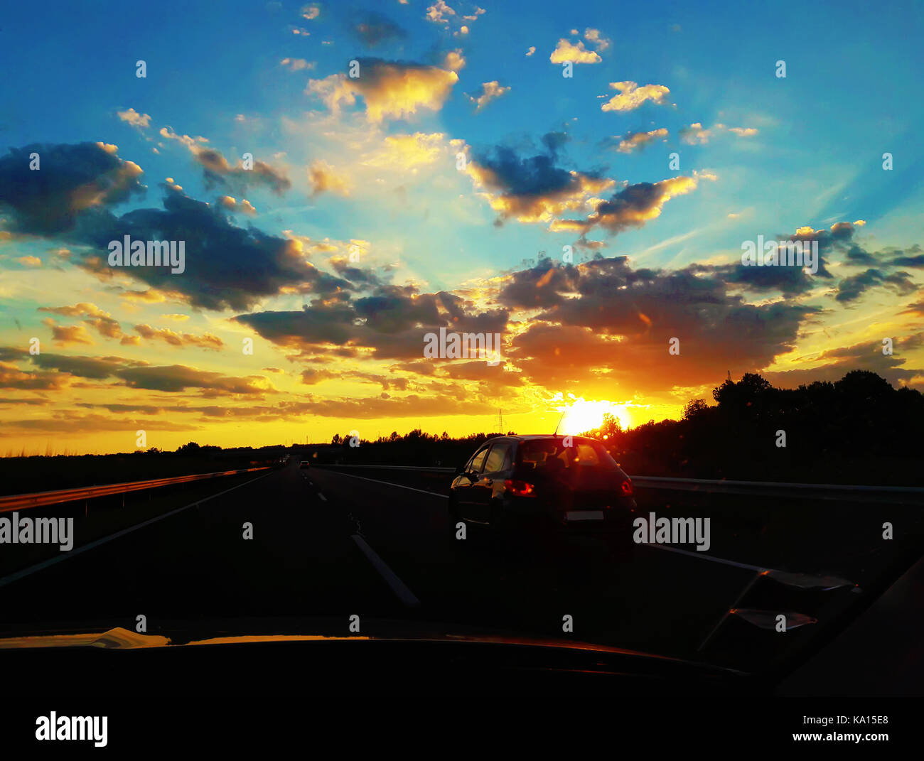 Die unvergessliche Reise mit einem Auto auf einer ungarischen Autobahn Straße treffen einen herrlichen Sonnenuntergang. Stockfoto