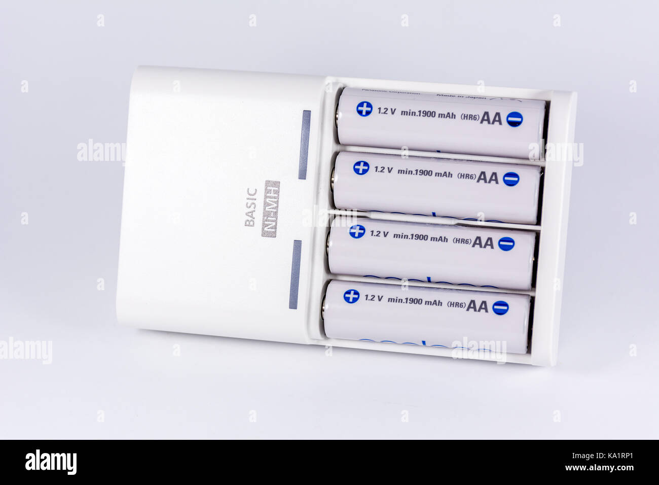 Universal Akku Ladegerät mit 4 Akkus auf weißem Hintergrund Stockfoto