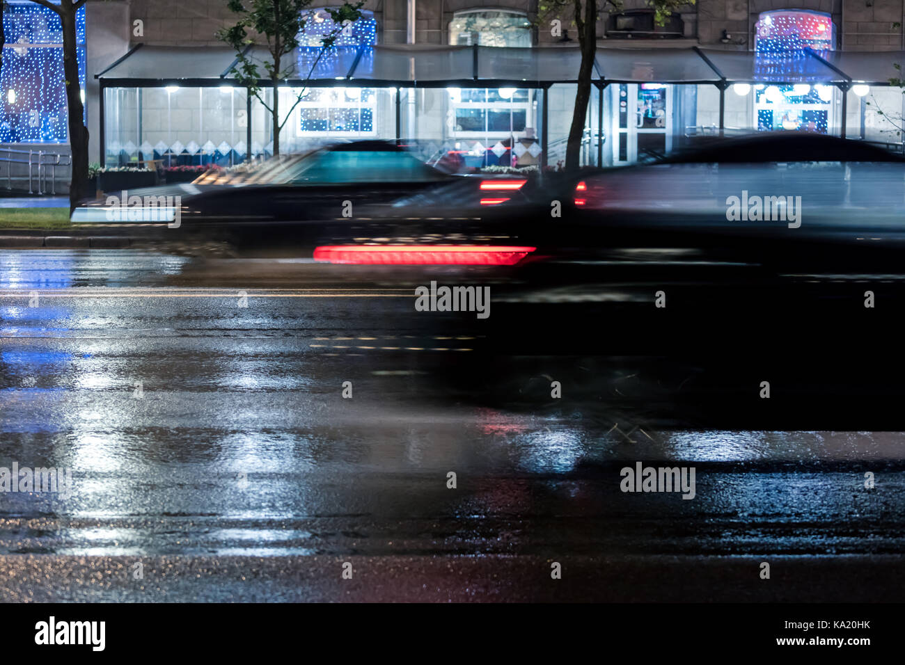 Autos schnell auf nasser City Road bei Regen. verschwommene Bewegung. Stockfoto