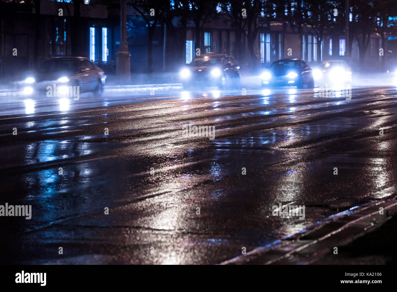Stadt Verkehr in der Nacht. Autos auf nasser Straße nach Regen zu fahren. Stockfoto