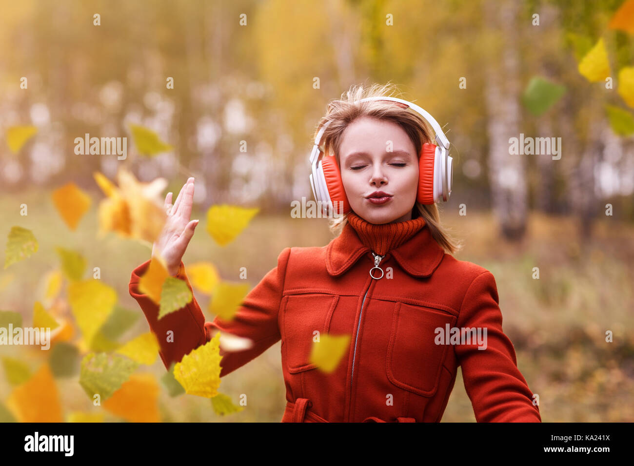 Junge Frau mit Kopfhörer tanzen im Park. Stockfoto