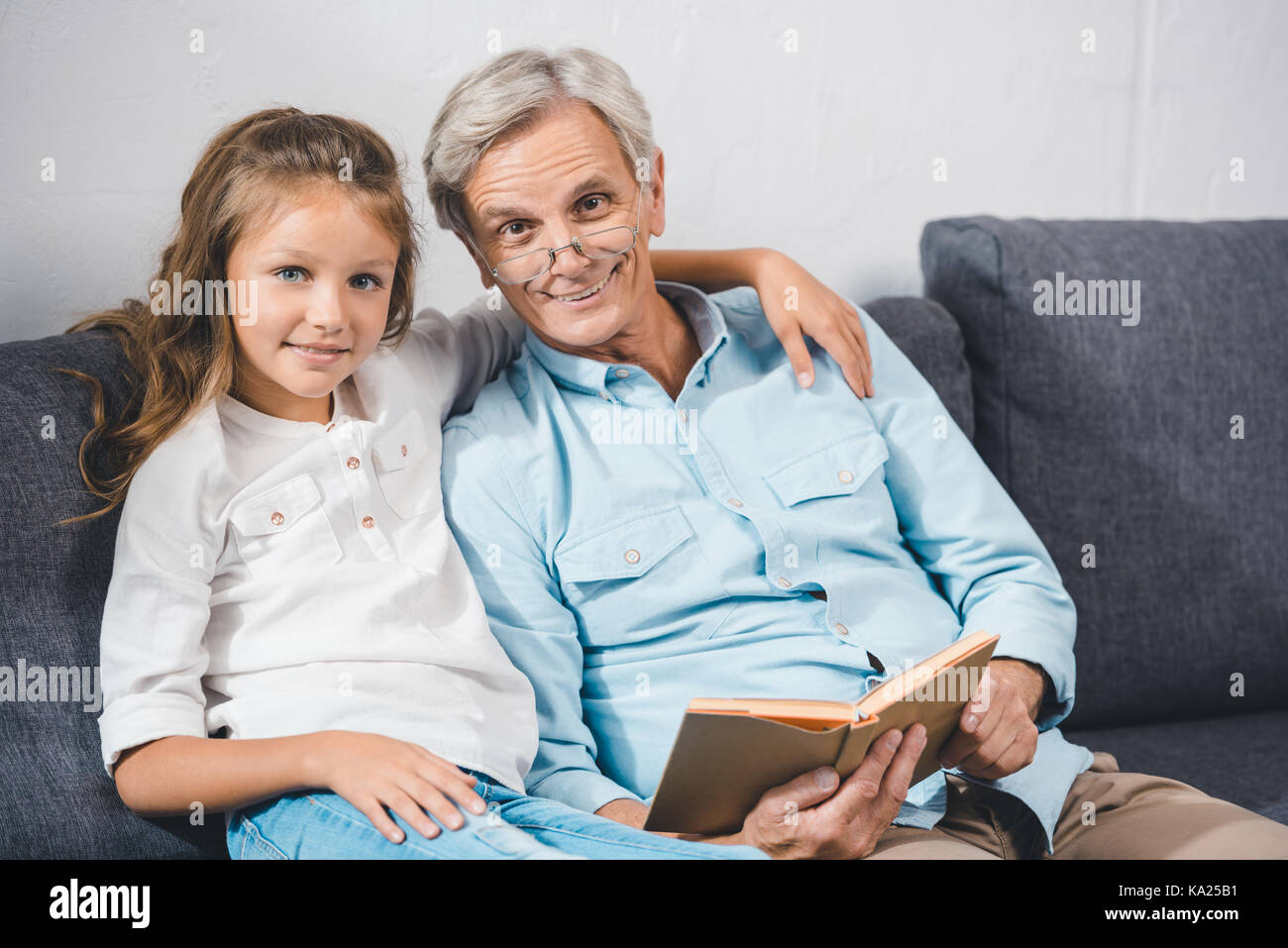 Großvater und Enkelin lesen Buch Stockfoto