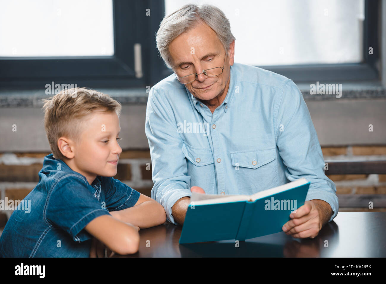 Großvater und Enkel lesen Buch Stockfoto