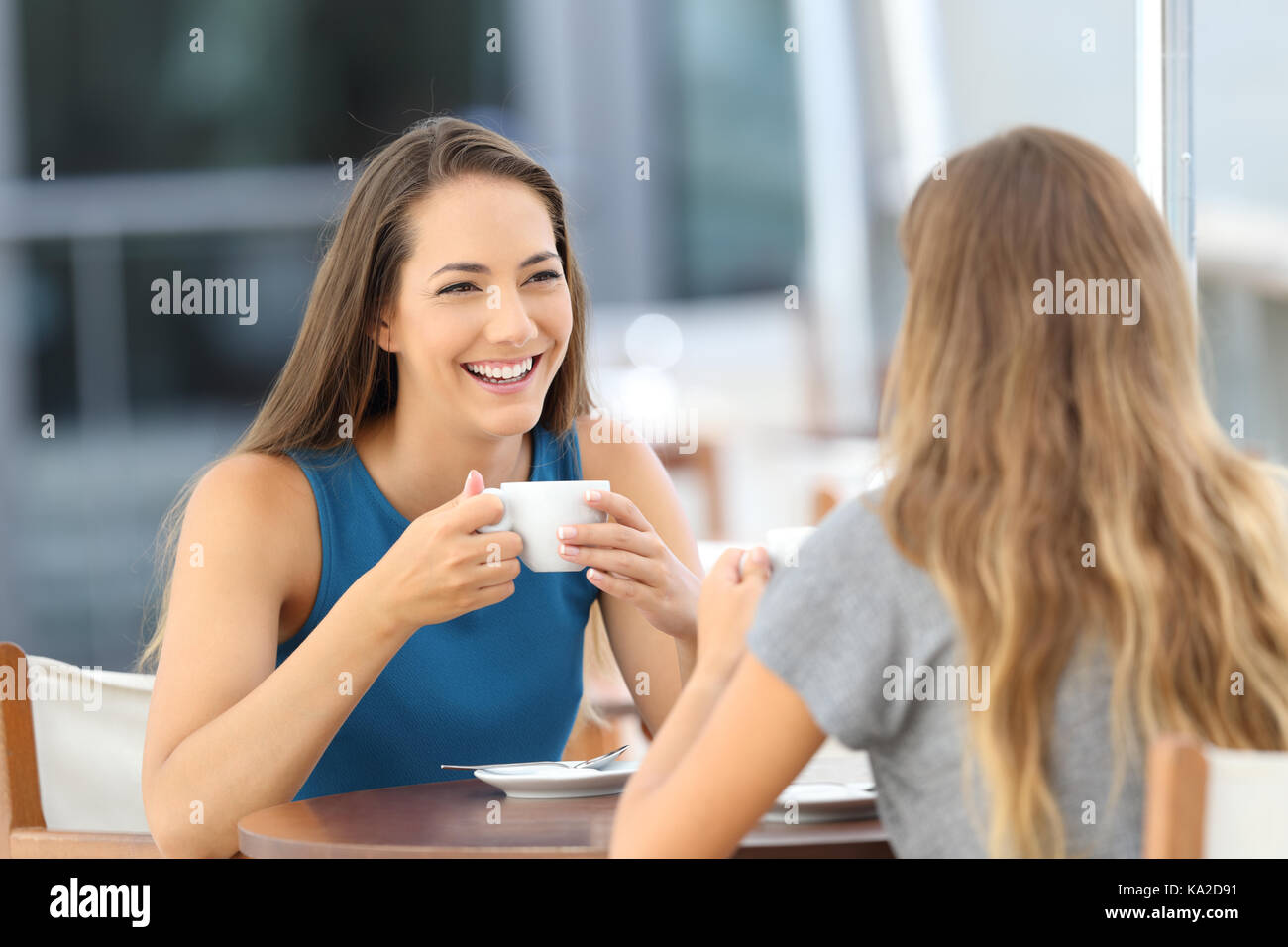 Zwei glückliche Freunde in einer ungezwungenen Gespräch in einer Bar auf der Terrasse sitzen Stockfoto