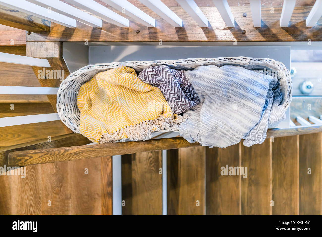Nahaufnahme der Wäsche oder Handtücher wooven Korb mit warmen Decken gefüllt über Treppen im Innenbereich in der Inszenierung Modell, Haus, Haus, Wohnung Stockfoto