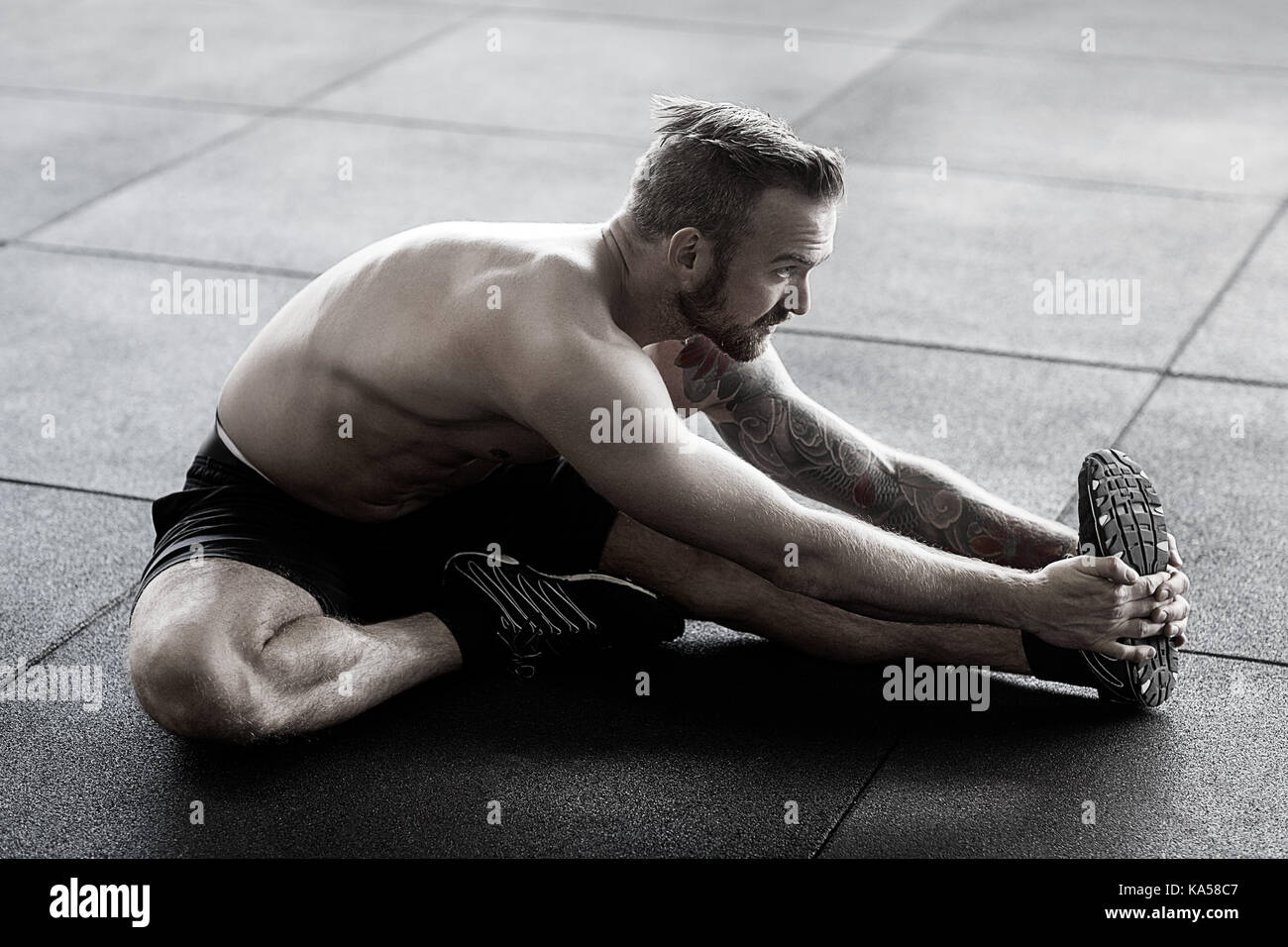 Mann zu tun Stretching Training im Fitnessraum Stockfoto