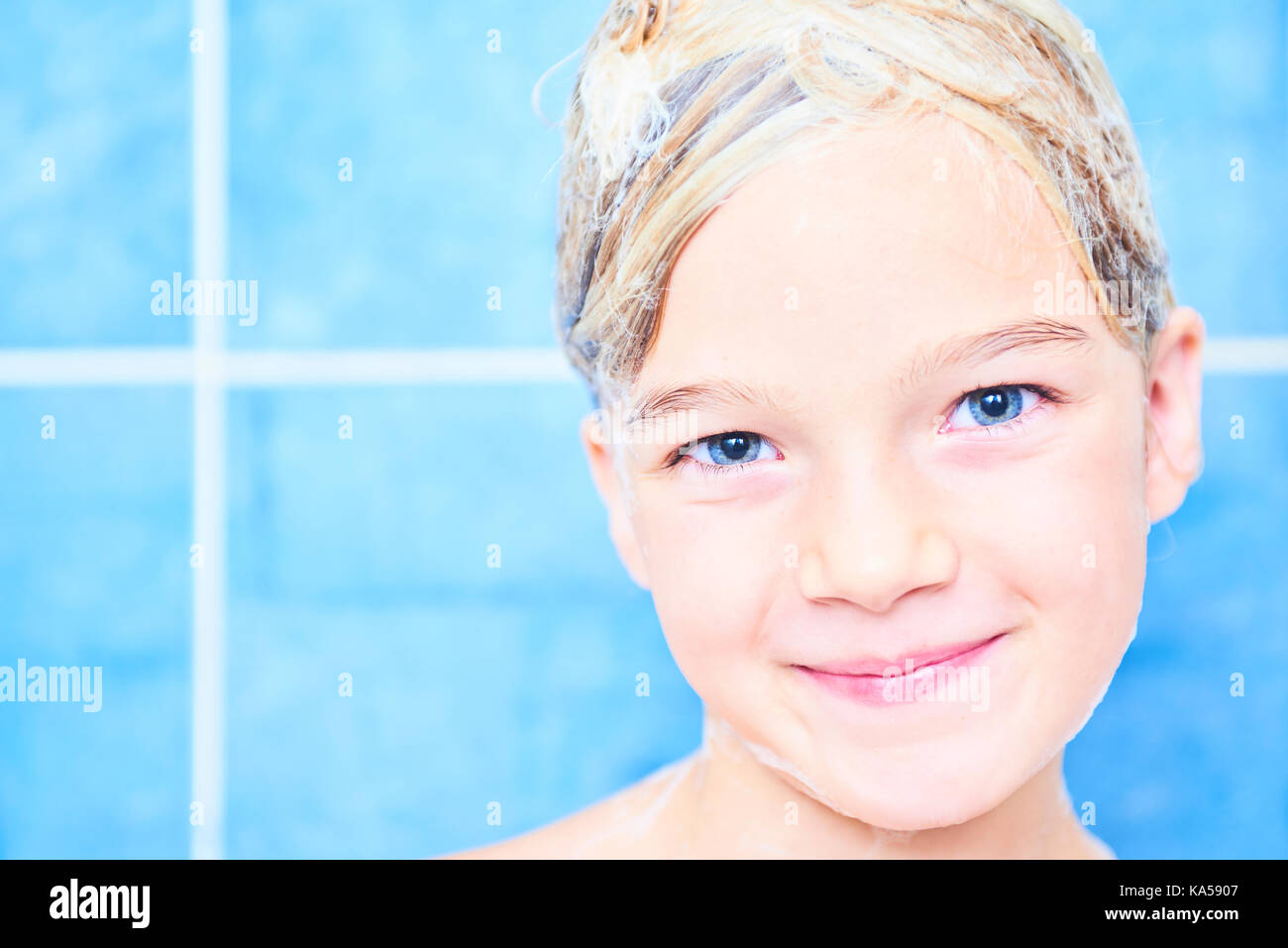 Kind, Mädchen mit nassen langen Haar nimmt ein Schaumbad. Waschen ihre Haare mit Shampoo und Spaß haben Stockfoto