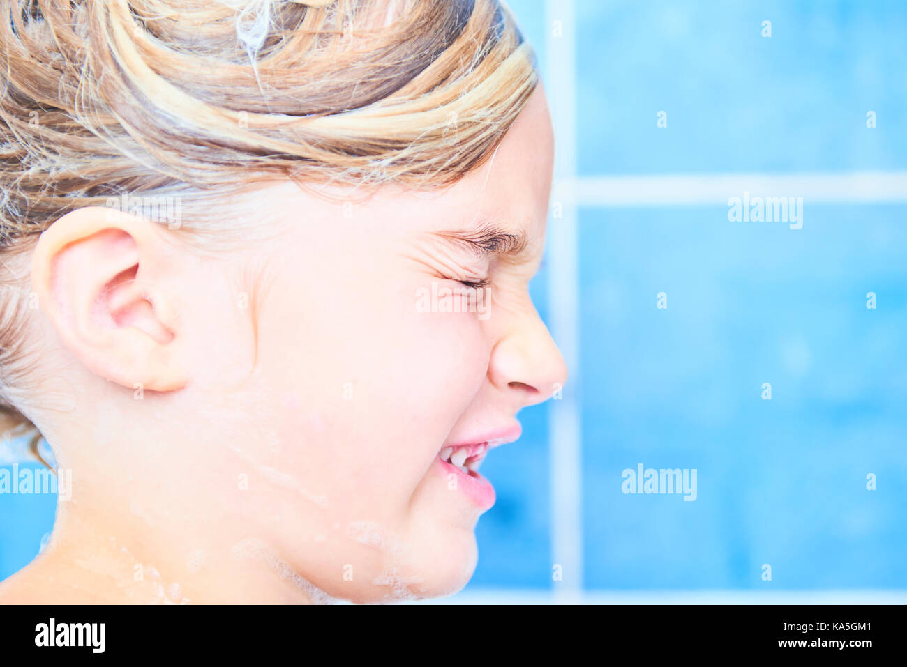 Kind, Mädchen mit nassen langen Haar nimmt ein Schaumbad. Waschen ihre Haare mit Shampoo und Spaß haben Stockfoto