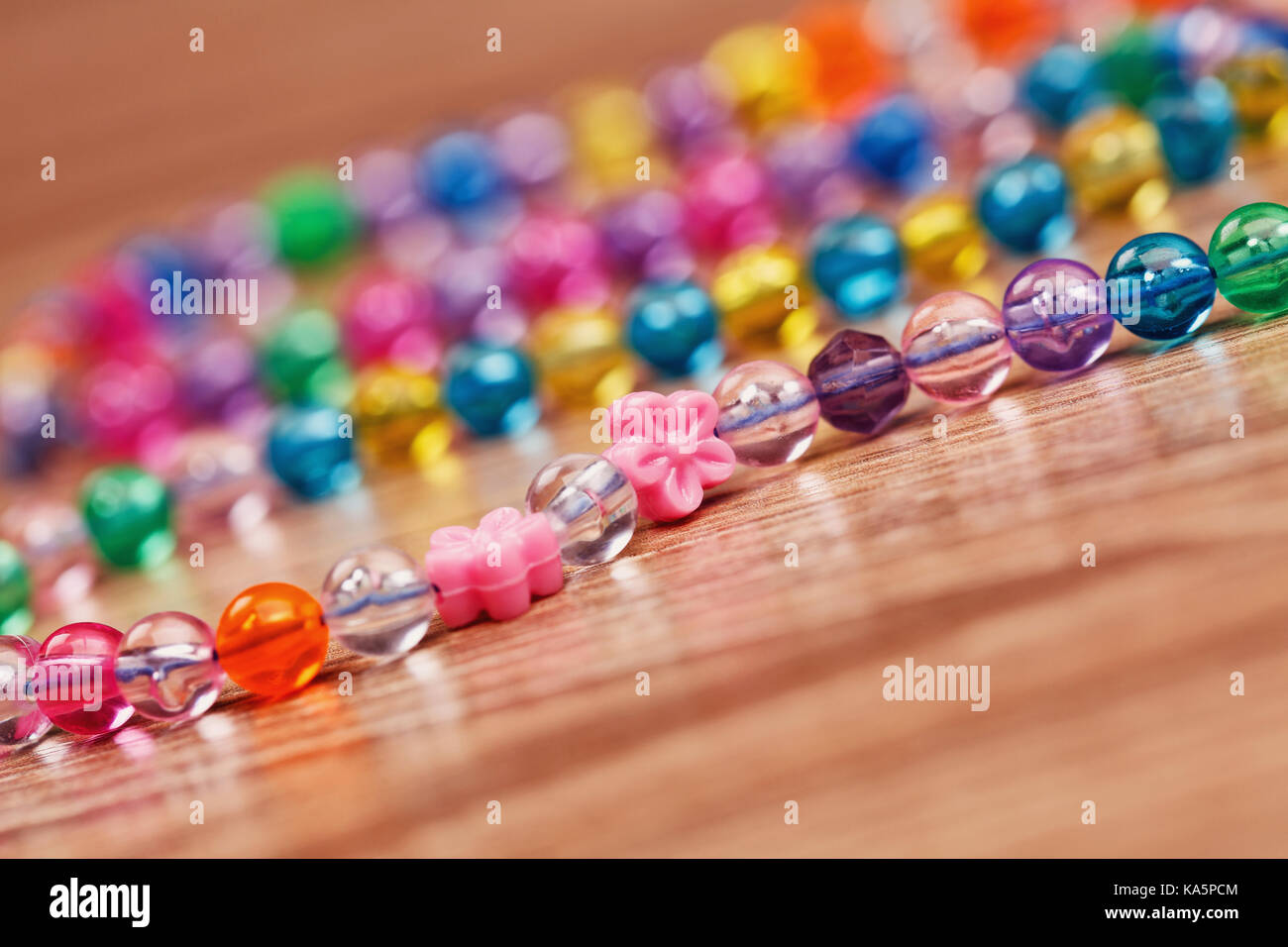 Von einem farbigen Perlen Halskette auf einem Holztisch gewebt. Stockfoto