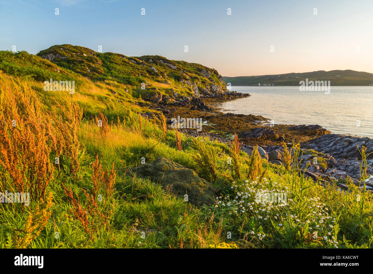 Landschaft von Port Ellen, über den Ozean mit Port Ellen Leuchtturm im Hintergrund, im Abend Licht gesehen, Port Ellen, Islay, Schottland Stockfoto