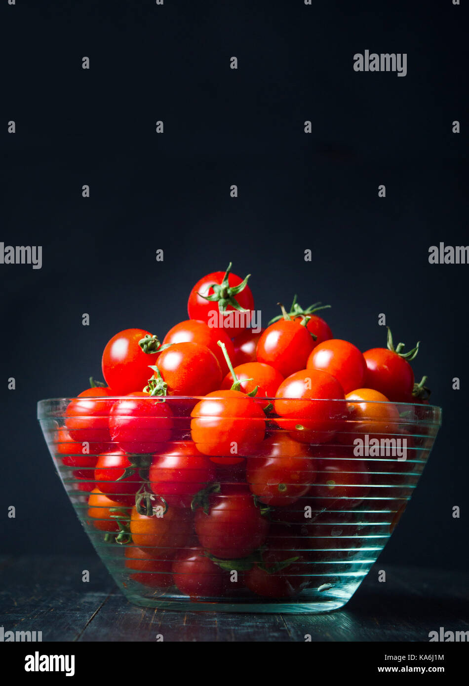 Kirsche Tomaten in eine Schüssel auf dunklem Hintergrund Stockfoto