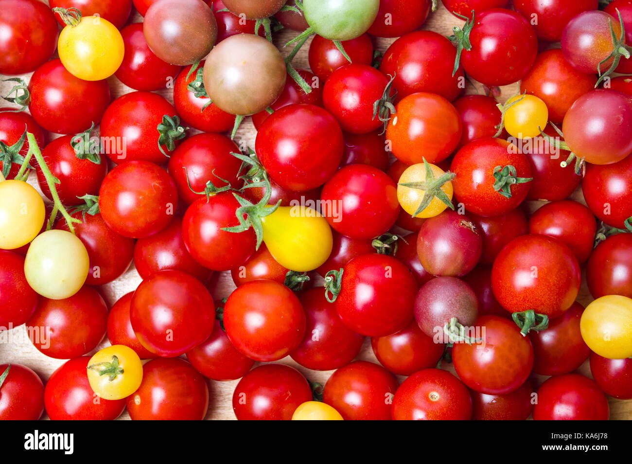 Bündel von ganzen Cherry Tomaten bilden Hintergrund Stockfoto