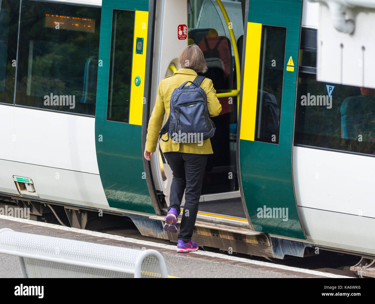 Frau an Bord eines südlichen Rail Zug an einer britischen Bahnhof in England, Großbritannien. Stockfoto