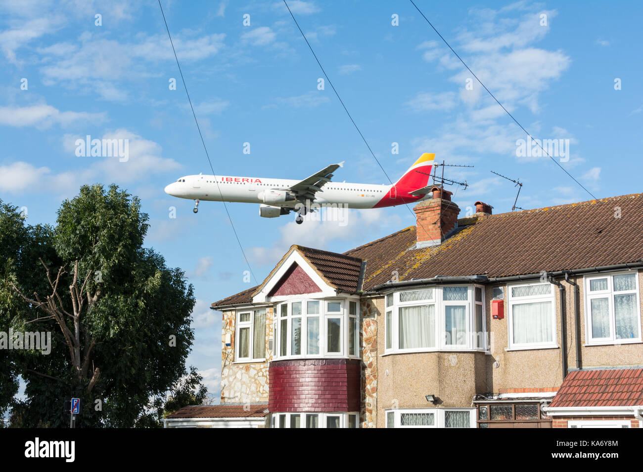 Ein tief fliegenden Iberia airline Flugzeug über Häuser auf Myrtle Avenue fliegen, in Hounslow, vor der Landung am Flughafen Heathrow, Terminal 4. Stockfoto