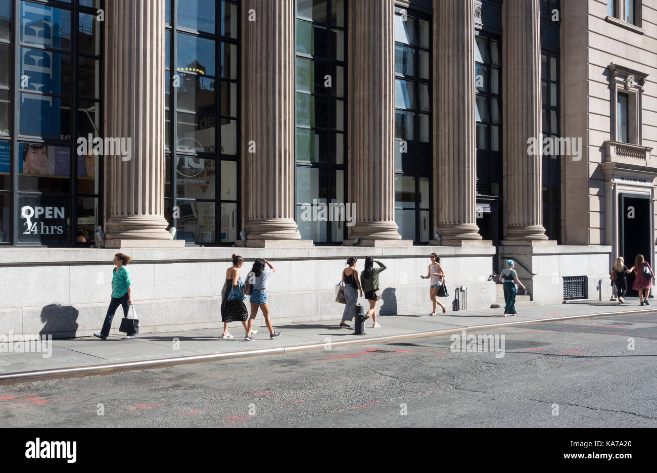 Frauen lebhaft gehen mit Zweck entlang einer Straße in Lower Manhattan in New York City Stockfoto