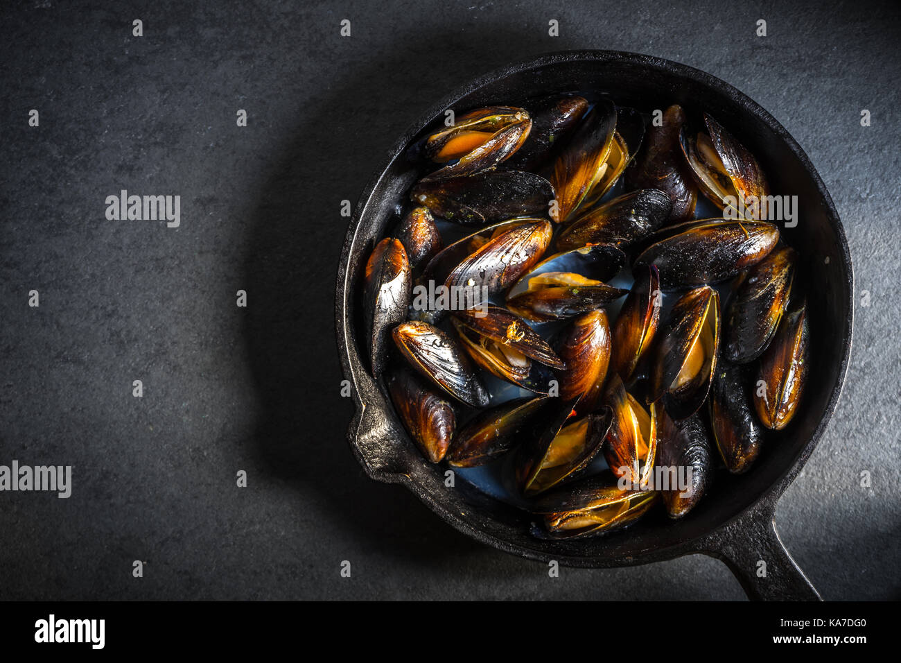 Muscheln auf einer gusseisernen Pfanne auf einem grauen Hintergrund freien Speicherplatz, horizontal Stockfoto