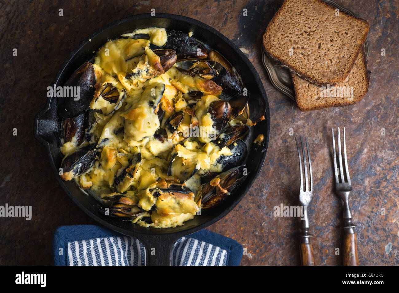 Muscheln in einer Pfanne mit Käsesoße, Serviette in die blauen Streifen horizontal Stockfoto