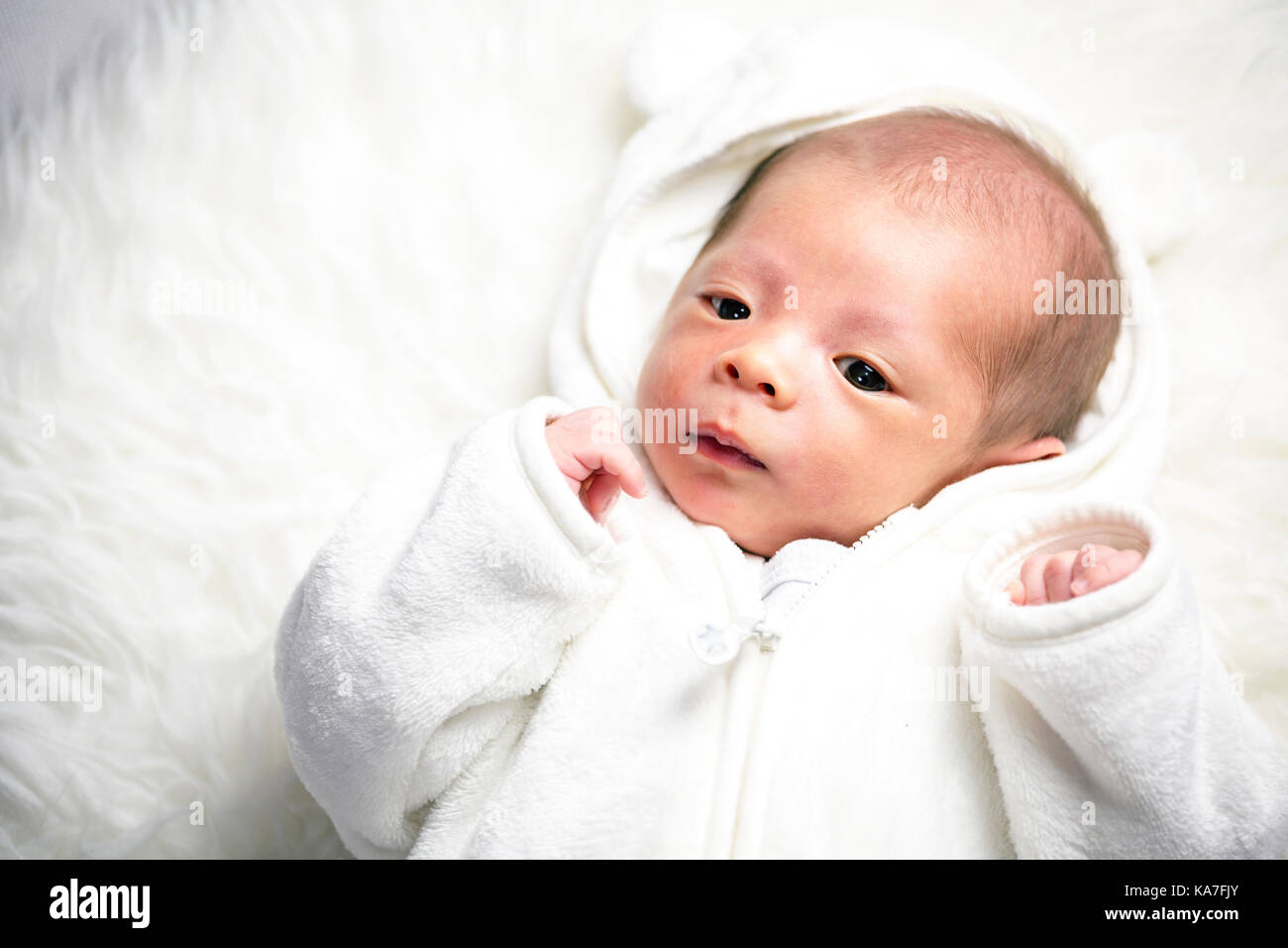 Süße kleine Junge, ein Monat alt, in weißem Kleid Stockfoto