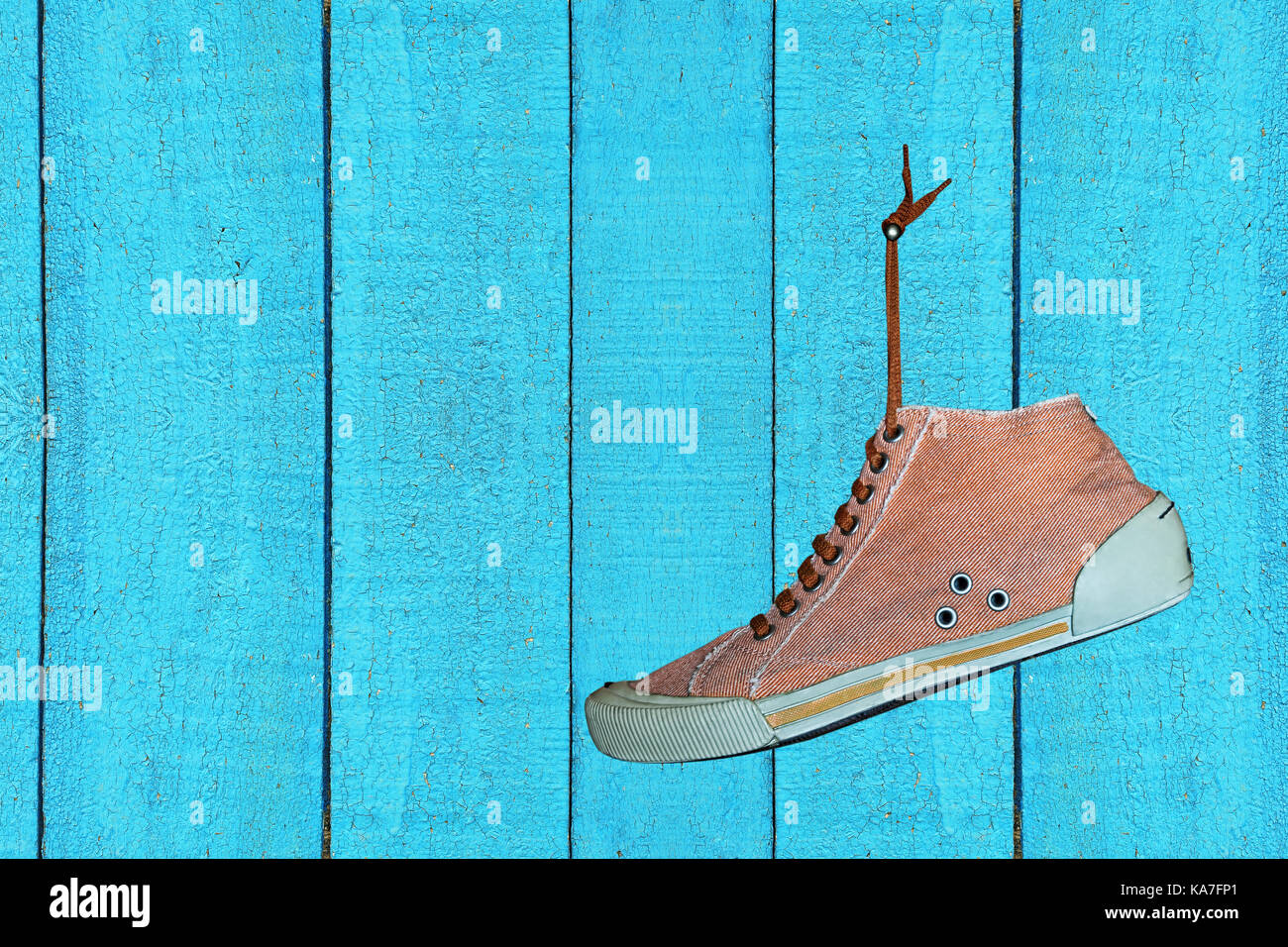 Single Trendy Fitnessraum Schuh hängt an blau gefärbt hölzerne Mauer closeup. leeren Raum für Text. Stockfoto