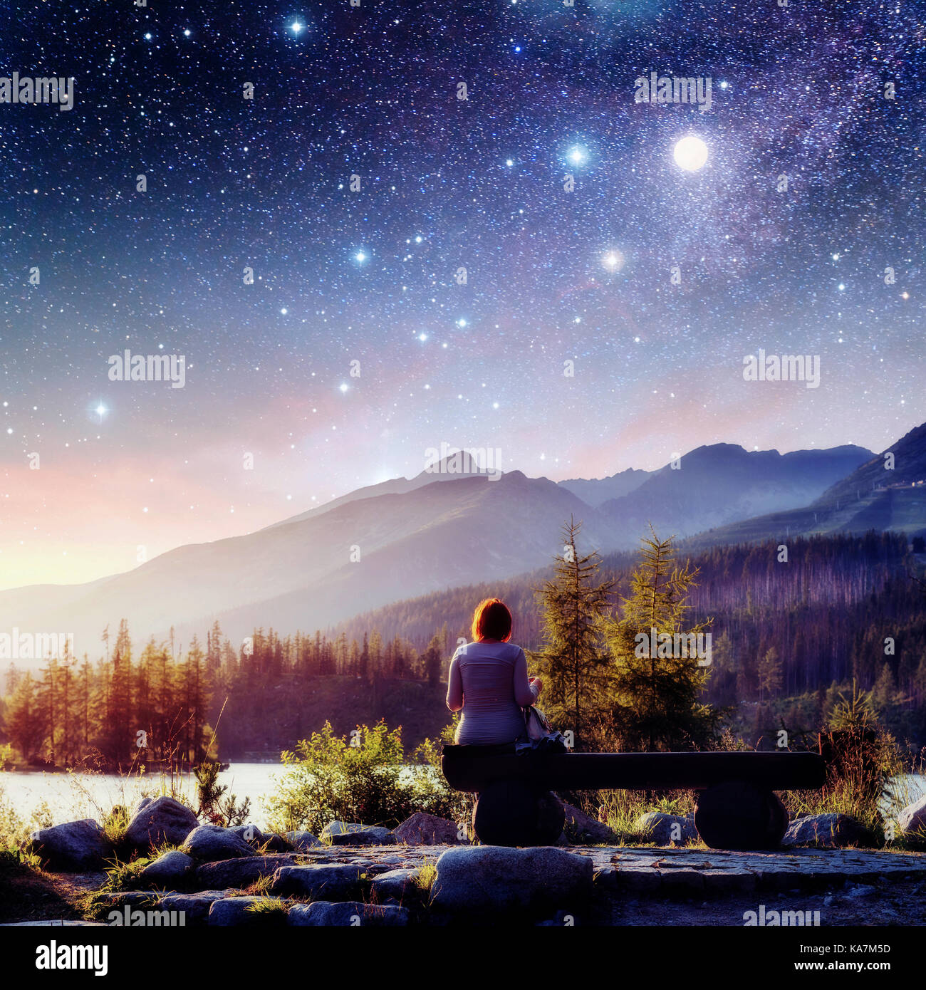 See Strbske Pleso in der hohen Tatra, Slowakei, Europa. Fantastischen Sternenhimmel und die Milchstraße. Das Mädchen sitzt auf einer Bank und schaut in den Märchen Himmel. Stockfoto