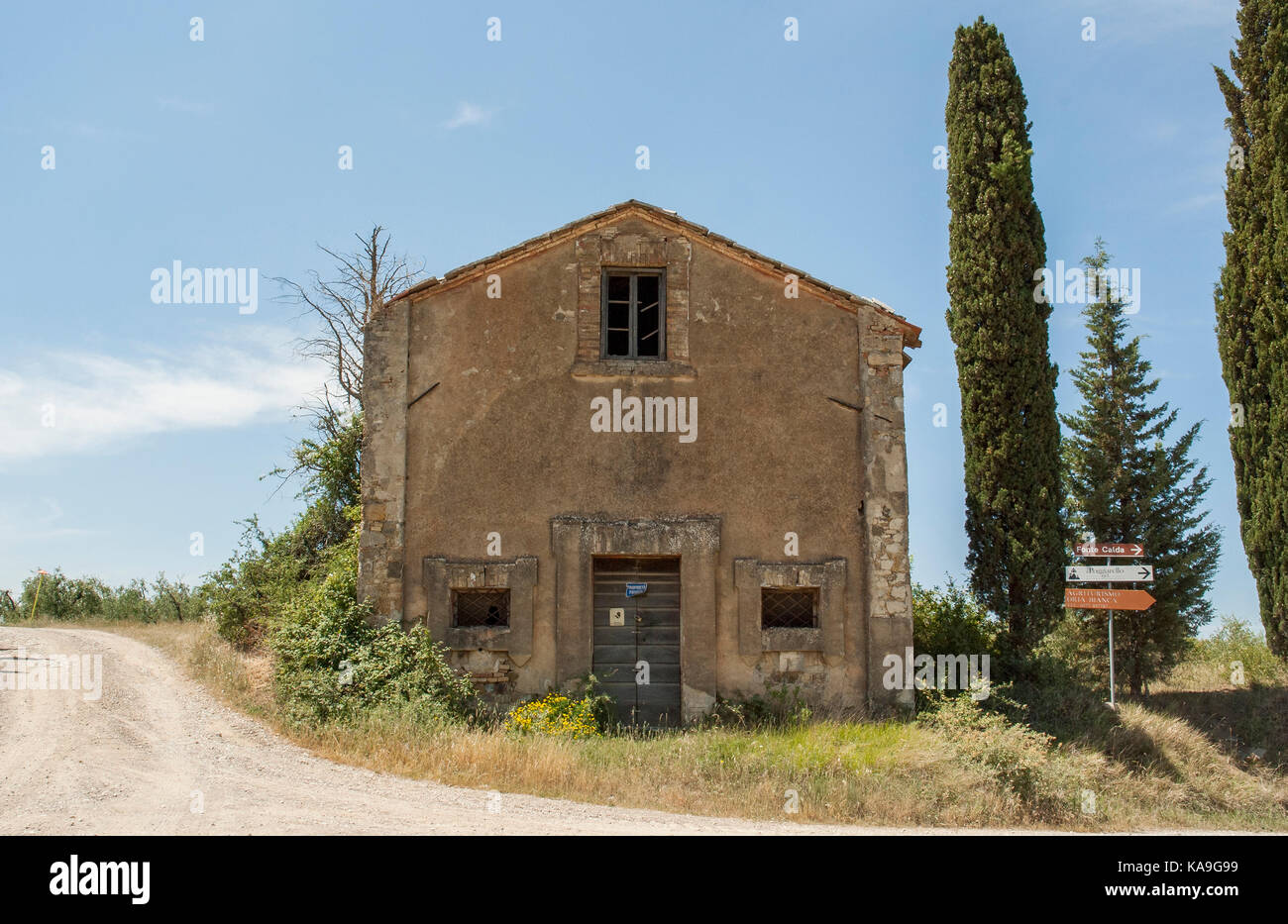 Toskana - 1. JUNI: verlassenes Haus mit Bäumen neben einer Landstraße in Val d'Orcia, Toskana, Italien, Juni 1,2017. Stockfoto