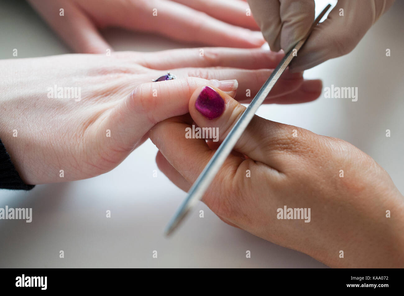 Professionelle Manikuristin manikuriert Kunden Fingernägel in einem Nagelsalon, Nahaufnahme der Hände Stockfoto