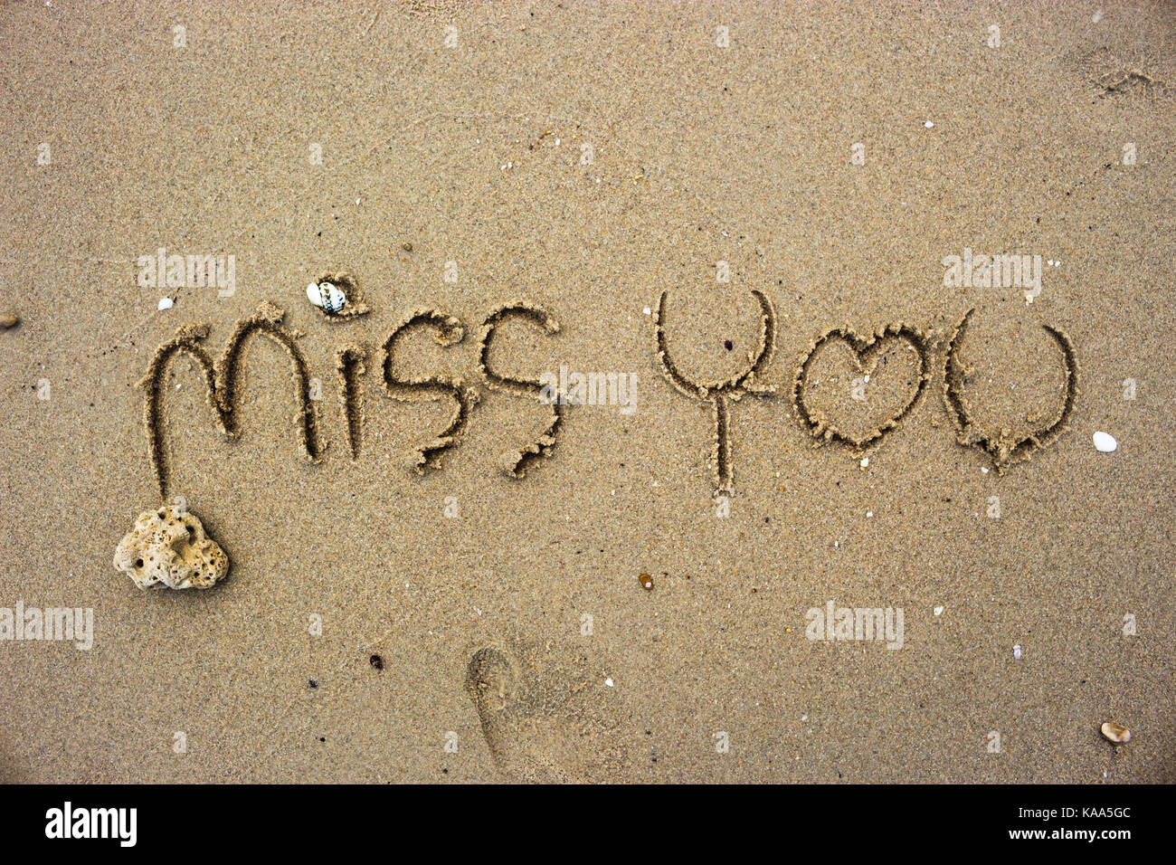 Schreiben verpassen Sie schrieb über den Sand Hintergrund. Stockfoto