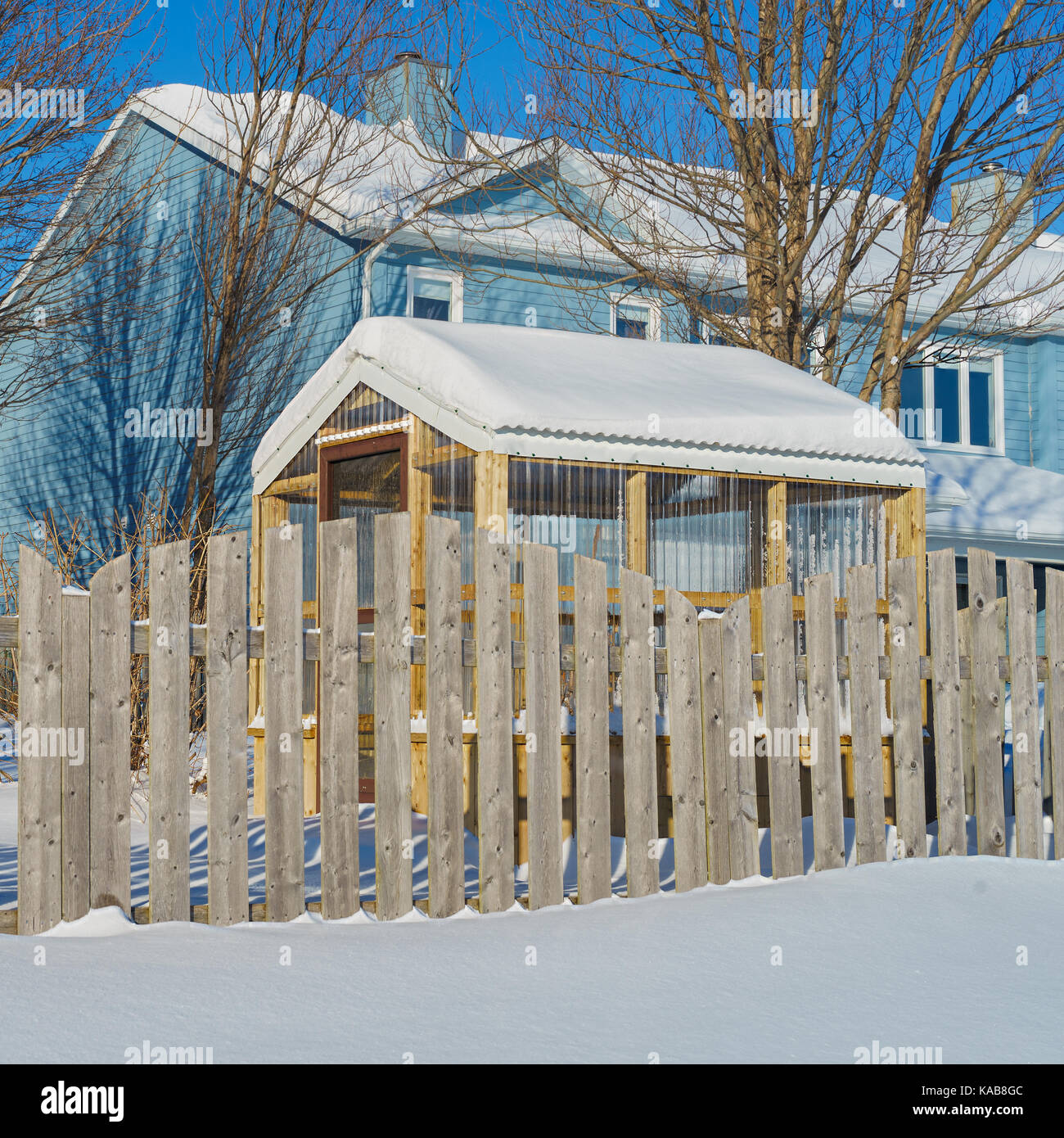 Kleine Holz Gewächshaus in einem verschneiten Hinterhof. Stockfoto