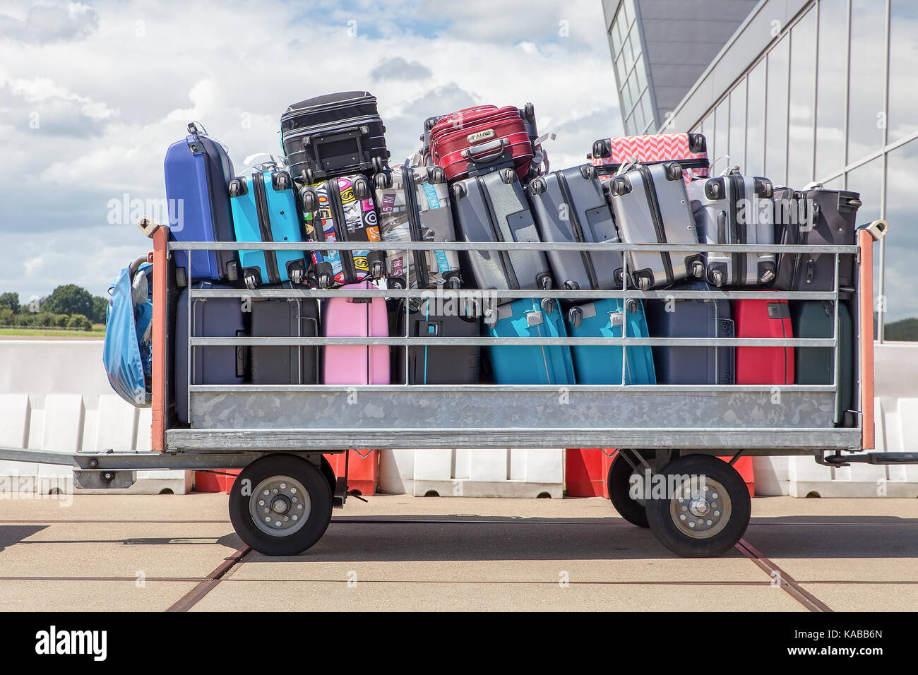 Trailer draußen auf Flughafen mit Koffern gefüllt Stockfoto