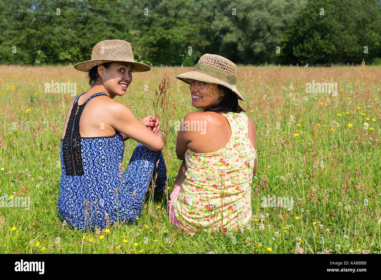 Zwei Freunde mit Hüte zurück schauen in der blühenden Wiese Stockfoto