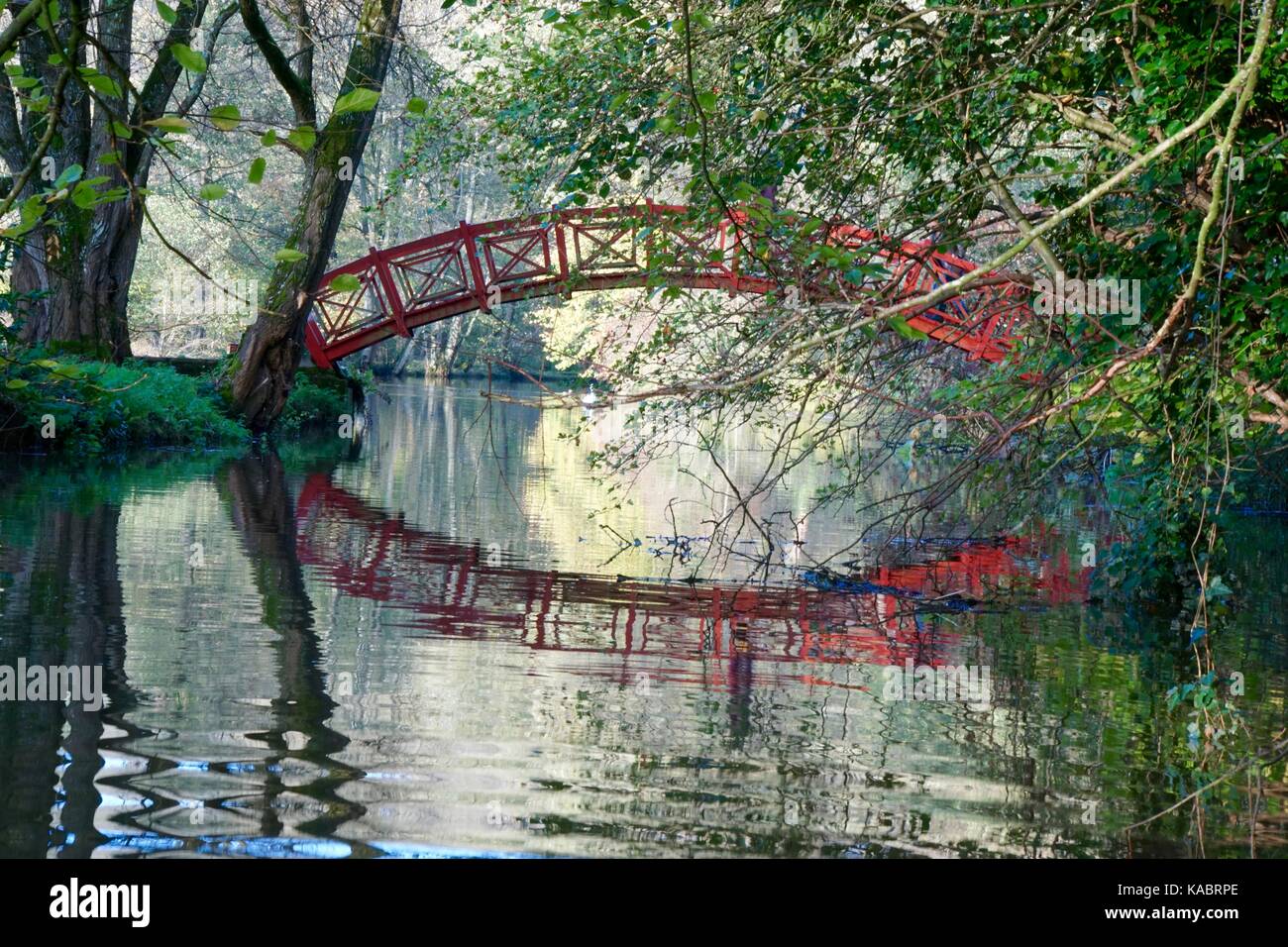 Rote Brücke über den See - in Wiltshire GROSSBRITANNIEN Stockfoto