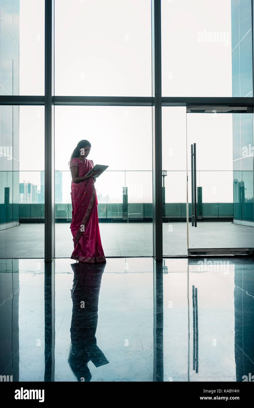 Indische Frau mit Tablette auf Korridor von modernen Corporate buildi Stockfoto